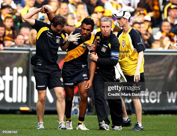Richard Tambling of the Tigers is assisted from the ground during the round eight AFL match between the Richmond Tigers and the Hawthorn Hawks at...