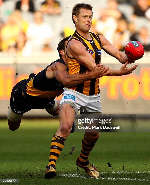 Sam Mitchell of the Hawks handballs as he is tackled by Alex Rance of the Tigers during the round eight AFL match between the Richmond Tigers and the...