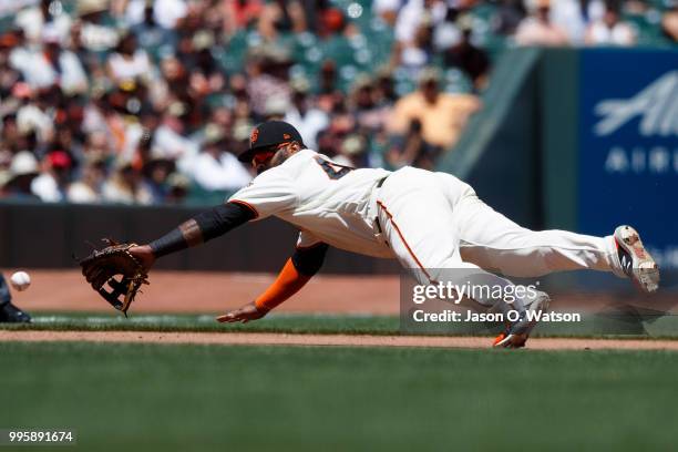 Pablo Sandoval of the San Francisco Giants dives for and fields a ground ball hit off the bat of Marcell Ozuna of the St. Louis Cardinals during the...