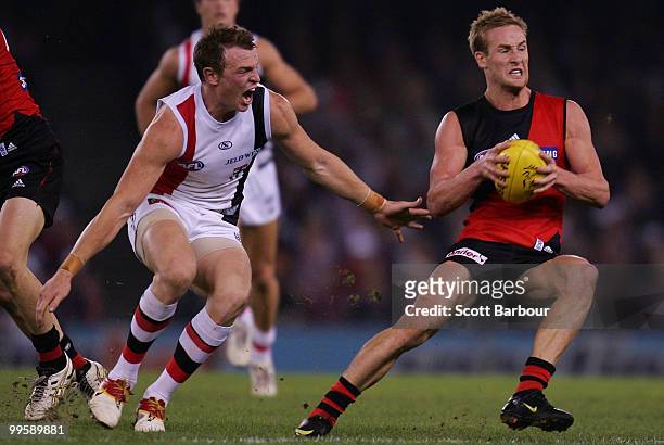 Jason Winderlich of the Bombers runs away from Brendon Goddard of the Saints during the round eight AFL match between the St Kilda Saints and the...