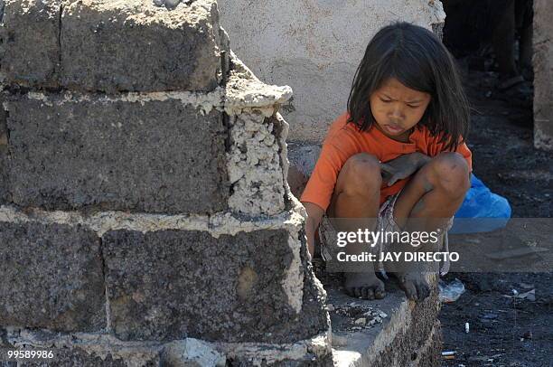 Resident looks for salvageable materials in a slum area in the debris after a fire gutted a sprawling shanty town on May 15 which left around 4,000...