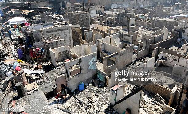 Residents look for salvageable materials in a slum area in the debris after a fire gutted a sprawling shanty town on May 15 which left around 4,000...