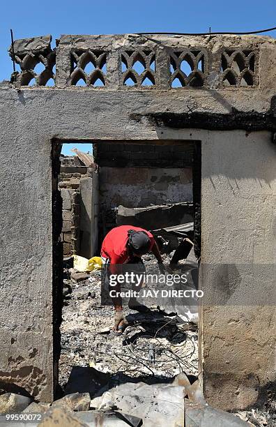 Resident looks for salvageable materials in a slum area in the debris after a fire gutted a sprawling shanty town on May 15 which left around 4,000...