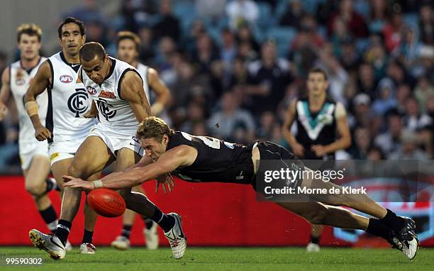 Jay Schulz of the Power dives to smother a kick from Chris Yarran of the Blues during the round eight AFL match between the Port Adelaide Power and...