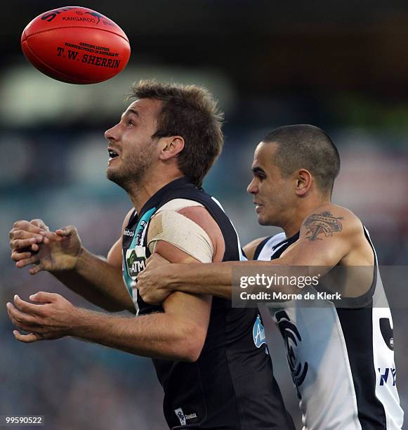 Tom Logan of the Power is tackled by Jeff Garlett of the Blues during the round eight AFL match between the Port Adelaide Power and the Carlton Blues...