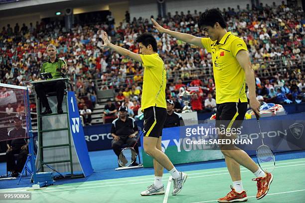 China's pair Cai Yun and Fu Haifeng motion for Indonesia's Markis Kido and Hendra Setiawan to wait during the finals round of the Thomas Cup...