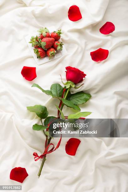 rose, petals and strawberry on bed - rose petals on bed stock pictures, royalty-free photos & images