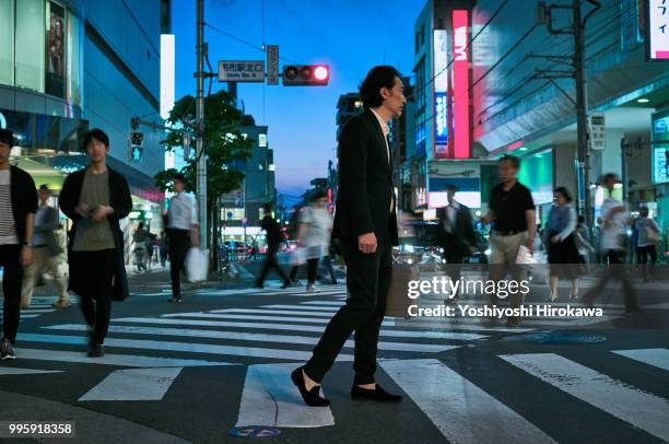 the middle-aged businessman walking free intersection in twilight at tokyo - chofu stock pictures, royalty-free photos & images