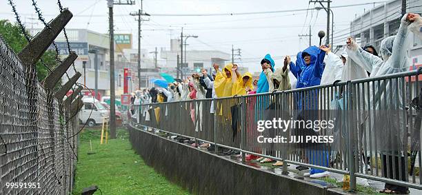 People stage a 13 kilometre long human chain around the US Marine Corps Futenma Air Station in Ginowan, Okinawa Prefecture on May 16, 2010 to protest...