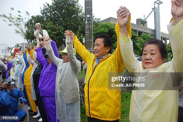 People stage a 13 kilometre long human chain around the US Marine Corps Futenma Air Station in Ginowan, Okinawa Prefecture on May 16, 2010 to protest...