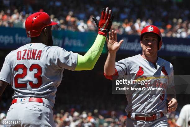 Jedd Gyorko of the St. Louis Cardinals is congratulated by Marcell Ozuna after scoring a run against the San Francisco Giants during the fourth...