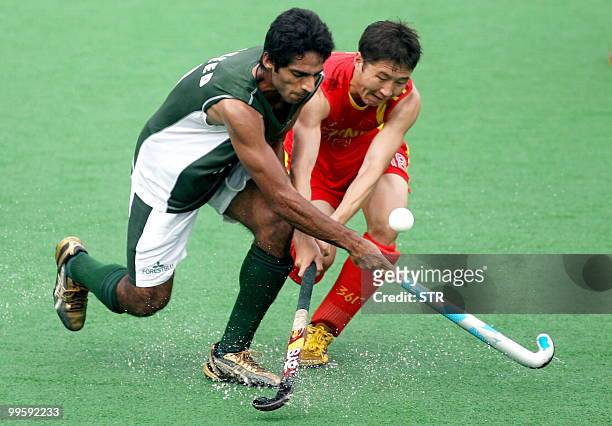 Pakistani field hockey player Ahmed Fareed vies for the ball with Chinese player Meng Jun during their match in the Sultan Azlan Shah Cup field...