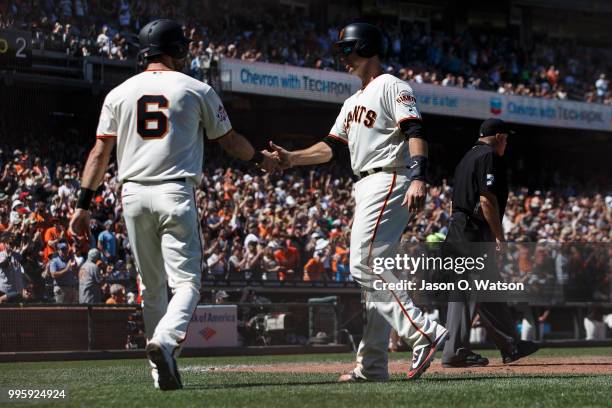 Buster Posey of the San Francisco Giants celebrates with Steven Duggar after both scored runs on a single by Pablo Sandoval , against the St. Louis...