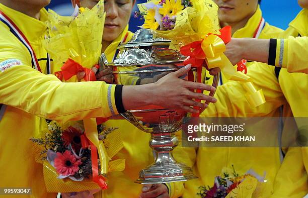 Gold medalist China team players pass on the trophy after defeating Indonesia in the Thomas Cup badminton championships final in Kuala Lumpur on May...