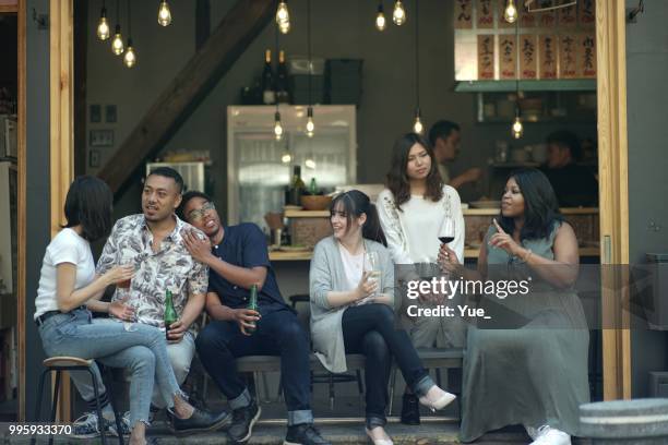 Various ethnic young people enjoying drinking together