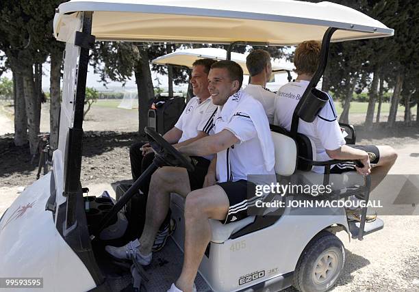 Germany's striker Lukas Podolski drives a golf cart following a training session at the Verdura Golf and Spa resort, near Sciacca on May 16, 2010....