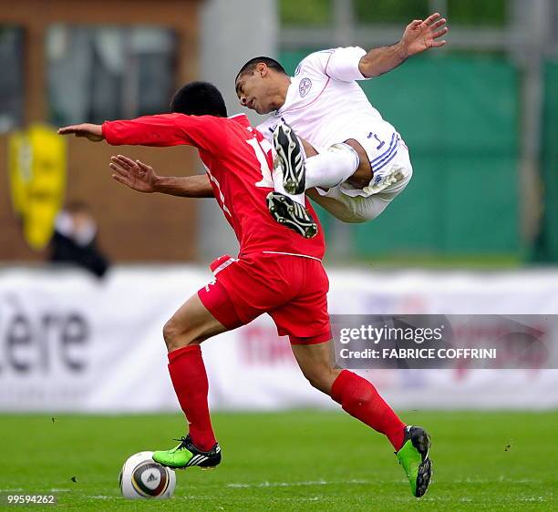 Paraguay's Paulo Da Silva falls behind North Korea's An Yong Hak during a friendly football match ahead of their participation to the FIFA World Cup...