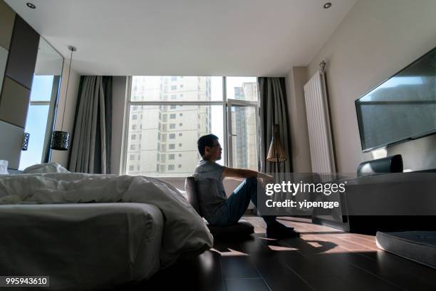 man watching tv in apartment - tranquilizing stock pictures, royalty-free photos & images