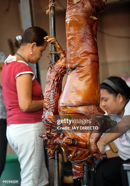 Customer buys roasted pig in La Loma district of Manila on May 16 during an annual festival. Roast pigs, called 'lechon' remain hugely popular in the...