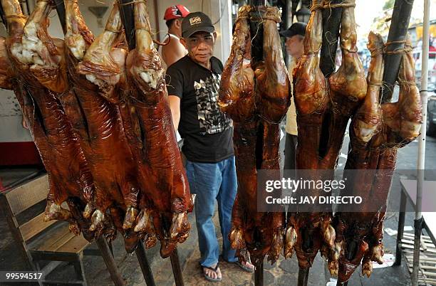 Customer buys roasted pig in La Loma district of Manila on May 16 during an annual festival. Roast pigs, called 'lechon' remain hugely popular in the...