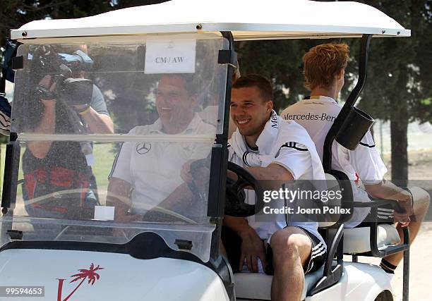 Lukas Podolski of Germany drives a golf cart after the German National Team training session at Verdura Golf and Spa Resort on May 16, 2010 in...