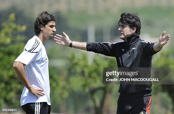 Germany's midfielder Samir Khedira speaks with Germany's head coach Joachim Loew during a training session at the Verdura Golf and Spa resort, near...