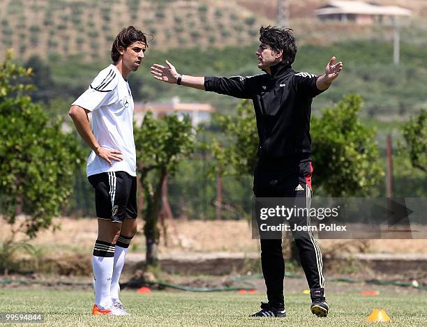 Head coach Joachim Loew of Germany talks to Sami Khedira during the German National Team training session at Verdura Golf and Spa Resort on May 16,...