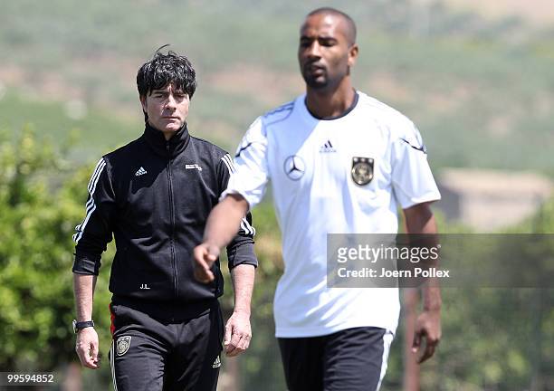 Head coach Joachim Loew of Germany talks to Cacau of Germany during the German National Team training session at Verdura Golf and Spa Resort on May...