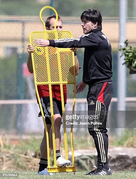 Head coach Joachim Loew talks to assistent coach Hans Dieter Flick of Germany during the German National Team training session at Verdura Golf and...