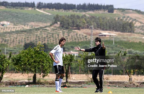 Head coach Joachim Loew of Germany talks to Sami Khedira during the German National Team training session at Verdura Golf and Spa Resort on May 16,...