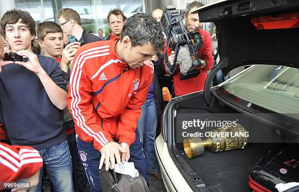 Bayern Munich's Dutch midfielder Mark van Bommel is photographed by fans as he puts the DFB German Cup trophy in the boot of a car after arriving at...