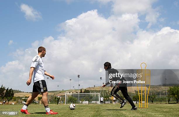 Head coach Joachim Loew and Lukas Podolski of Germany are seen in action during the German National Team training session at Verdura Golf and Spa...