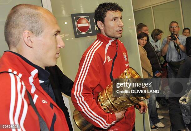 Bayern Munich's Dutch striker Arjen Robben and Dutch midfielder Mark van Bommel arrives at the airport with the trophy in the southern German city of...