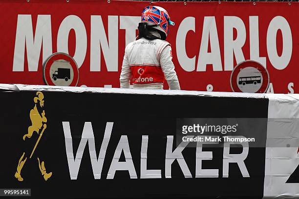 Jenson Button of Great Britain and McLaren Mercedes walks back to the pits after retiring early with an engine problem during the Monaco Formula One...