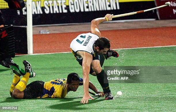 Malaysian field hockey player Saari Faizal collides with Australain player Ian Burcher in an attempt to score during their match in the Sultan Azlan...
