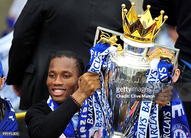 Didier Drogba holds the League Cup aloft as the Chelsea Football Team parade their silverware on an open top bus on the Kings Road, Chelsea, on May...