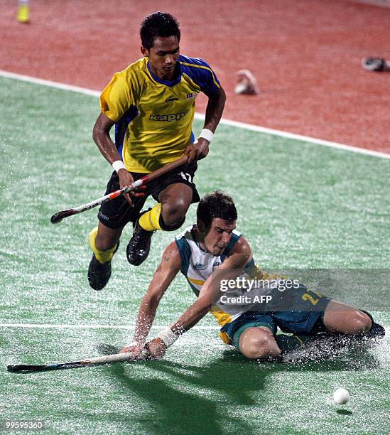 Malaysian field hockey player Abdul Rahim Muhd Razie leaps over Australain field hockey player Kieran Govers during their match in the Sultan Azlan...