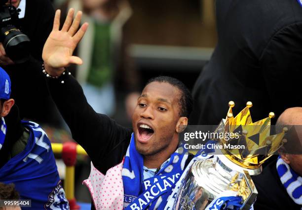 Didier Drogba holds the League Cup aloft as the Chelsea Football Team parade their silverware on an open top bus on the Kings Road, Chelsea, on May...