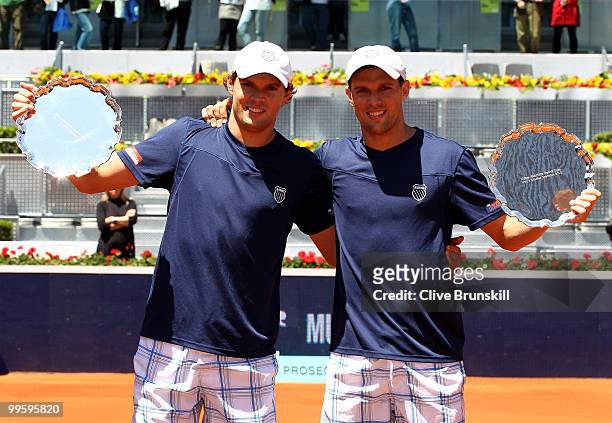 Mike Bryan and Bob Bryan of the USA hold their winners trophies aloft after their straight sets victory against Daniel Nestor of Canada and Nenad...