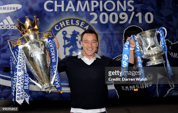 John Terry of Chelsea poses with the Premier League and FA Cup trophies prior to the Chelsea Football Club Victory Parade on May 16, 2010 in London,...