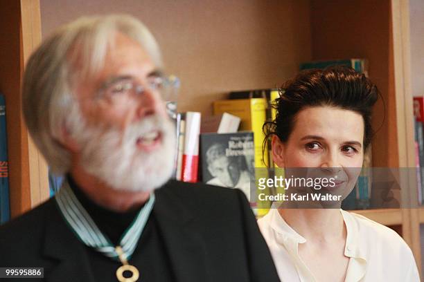 Actress Juliette Binoche looks on as Austrian writer and director Michael Haneke is awarded the Commander in the Order of Arts and Literature at the...
