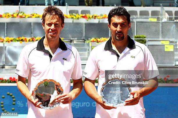 Daniel Nestor of Canada and Nenad Zimonjic of Serbia hold their runners up trophies after their straight sets defeat by Mike Bryan and Bob Bryan of...