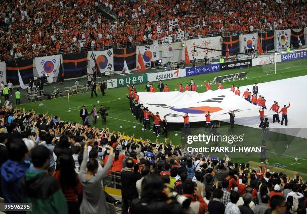 South Korean national football team players hold a huge national flag after a friendly football match with Ecuador in Seoul on May 16 ahead the...