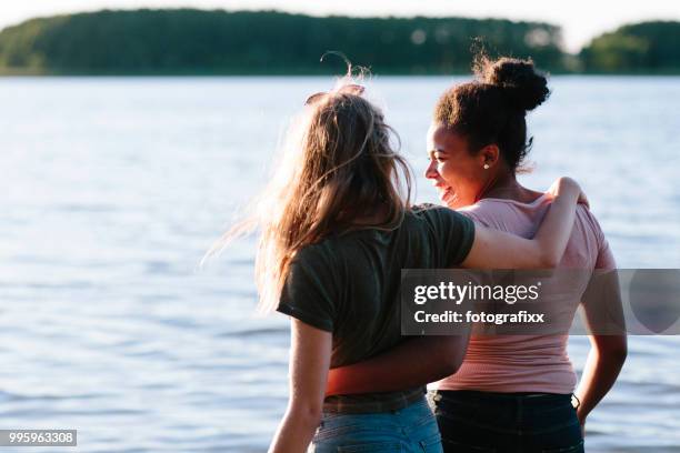junge frauen genießen einen unbeschwerten sommertag an einem see - haarknoten stock-fotos und bilder