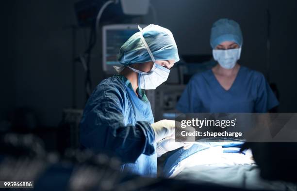 dévouement, c’est ce qui les pousse à faire de leur mieux - chirurgien photos et images de collection