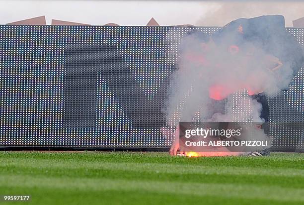 Roma's defender Marco Cassetti put out from the pitch a flare during their Italian serie A football match Chievo vs AS Roma, at Marc'Antonio...