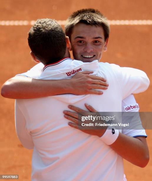 Andreas Beck of Germany celebrates after winning his match against Paul-Henri Mathieu of France with national coach Patrick Kuehnen during day one of...