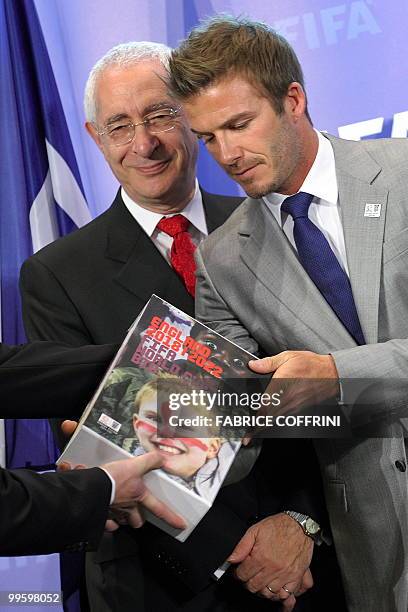 England 2018 World Cup bid chairman Lord Triesman stands behind former England football captain David Beckham receiving the FIFA World Cup bid book...