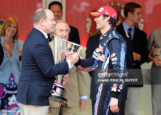Red Bull's Australian driver Mark Webber is given the winner's trophy by Prince Albert of Monaco on the podium of the Monaco street circuit on May 16...