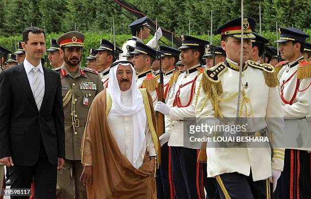 Syrian President Bashar al-Assad and Kuwaiti Emir Sheikh Sabah al-Ahmed al-Sabah review an honour guard upon the latter's arrival at Al-Shaab Palace...